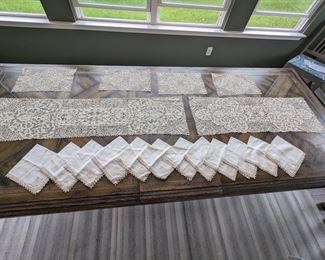 9.)  Set of 2 table runners, 4 placemats, and 12 Napkins with Figural designs in Mixed Laces.  Flemish, Belgian, and Cantu Laces.  Figural designs in each corner.  Napkins are linen with the figural motifs.  No structural issues but some Linen discoloration. 1st runner - 39" x 19", 2nd runner - 48" x 13".  Placemats - 10" x 15".   $325.00