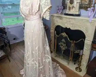 40.)  ca 1890's - 1900's Pink Tape Lace Gown, Pigeon Breasted.  Lace on gown is in very good condition except for staining on train.  The pink silk under dress is in good shape but has some stains.   The hem has dirt and stains along with an area that appeared to have been chewed.  Flounce on under skirt has also been damaged.   Pink hem could be replaced to get rid of damage.  Lace was not affected.   General condition is good.  Displays well.  Measures:  Shoulder to Shoulder - 14",  Bust - 30",  Waist - 24",  Length,- 61",  Length with train - 72".  $395.00