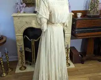 38)  ca 1890 - 1900's Chiffon and Lace Bridal/Wedding Gown.  Metallic lace on collar.  Pigeon breasted.  Satin belt shattering.  Slight train.  Stain on back and bottom of skirt.  Interior bodice shredding.  Slip may have been removed.   Very good condition.   Measures:  shoulder to shoulder - 12",  bust - 32",  Waist - 24",  Length 54".    $450.00