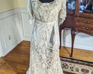 26.)  Ca 1900's Belgian Tape Lace Evening  Gown with Beading, Labeled.  Stunning tape lace gown with glass beading and embroidery.  Labeled "Kate Ker Lane, Victoria House, 1 Kensington High St. W".  Gown has train,  Inner lining is shattering.   Minor repair needed to lace.   Measures:  Shoulder to shoulder - 15",  Bust - 30",  Waist - 26", Length - 56",  Length with train - 68".   $750.00