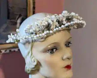 3)  ca 1920's Floral Wax Wedding Crown.  Crown is a 2 tier wrapped wire frame with wax orange blossoms and buds.  Satin ribbon hangs from the back.  Excellent condition.  Measures:  8 1/4" diameter.    $169.00
