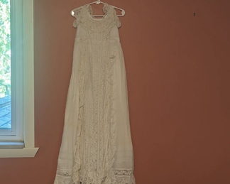 2.)  Antique Christening/Baptismal gown with slip.  Needlerun lace on netting.  Structurally sound but there is 1 old repair, a slight pink discoloration at the neckline in front, and a pink stain in back the size of a baby finger print.  Slip (original ?) has what looks like a water stain.  Measures:   front length 39",  back length 43".  $95.00