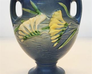 Many pieces of Roseville Pottery, including this Freesia vase and lamp.