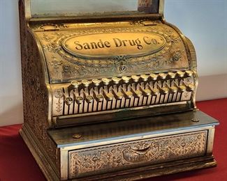 Great piece of history! This is a National Cash Register solid brass Model 47 1/4 cash register with side receipt cage. It was used in the Sande Drug Store in Laurel, Montana. The keys work and the bell rings when the door opens. Last patent date was June 15, 1897. Includes a copy of a letter dated January 27, 1942 from Mr. Charles B. Sande, Proprietor. In the letter he states that he is 62 years old and has "been in business 33 years in Laurel". We do not have keys for it. 19 1/2" wide, 17" tall, and 16" deep.