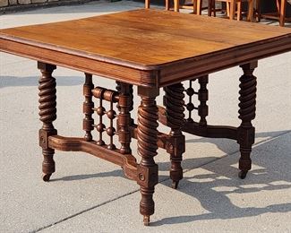 19th century expandable dining table with rope turned legs and an ornate spool turned base. The table is 44" wide. Without the leaves, it is 43" long. With all five leaves in, it measures 105 1/2". It stands 30 3/4" tall. 