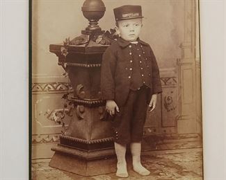 Pair of 6 1/2" x 4 1/2" cabinet photos show a young boy in a conductors outfit wearing a cap that says "Harrison Morton". These caps were given out as political items for the 1888 presidential campaign of Benjamin Harrison and Levi Morton.