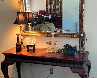 Gorgeous sofa, table, large, gold, framed mirror, wine, decanter, and beautiful accessories
