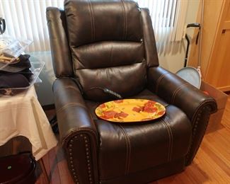 dark  brown  leather  motion (electric)  chair, platter  The  pric e  of  the  chair  on  Monday  is  100.00