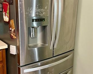 Full-size Refrigerator with bottom freezer drawer, water, and ice maker in the door.