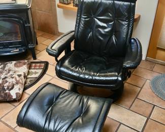 One of two black Stress Less chair and ottomans