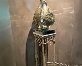 Silver Vase with gold Leaf Branch Design 22.5" H x 46" Round                                                                                                                     Metal Scroll Pedestal Table with Mirror Accents                        37.5" H x 11" Square