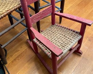 #37		Vintage red wooden Childs rocking chair w/ woven seat. 	($ 20.00)