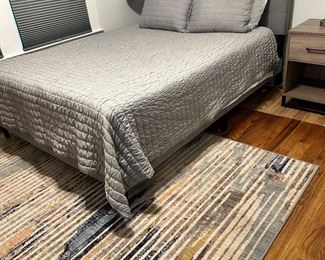 Zines Gray upholstered queen bed, Serta perfect sleeper queen, area rug and check out the cool floor lamp in the corner.  