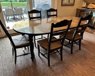 Wood-tone table top with black legs and 6 chairs