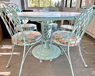 Wrought iron glass top table and 5 chairs.