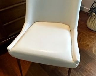 4 leather-like chairs with gold toned legs and back-handle detail