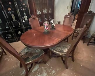 Drexel dining table with a leaf, and six cane back chairs. One of the cane back chairs is damaged, but the other five are in pristine condition.