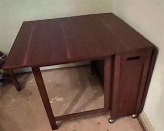 GORGEOUS!!! This 1960's MCM Rosewood Space saving, hide away, dropleaf table with four hidden folding chairs is AHHH-MAZING! Talk about an "uncommon" piece --- this is it!! It will be one of the first items to go out of the door! **Don't let it slip away!