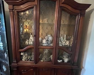 China cabinet with light and plenty of storage down below in the form of cabinets and hidden drawers.