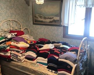 Vintage iron bed full of sweaters lots of designer names