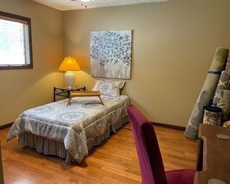 twin bed and mattress with linens, rugs, desk and high-back chair