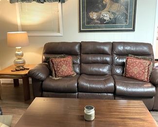 Brown leather sofa recliner and wood coffee and side tables