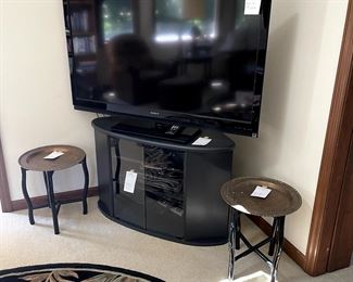 Large Sony TV.  TV stand. Pair small tables with brass trays.
