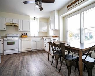 Pretty kitchen: solid wood cabinets painted white. Urban chic  dining table with 4 metal chars