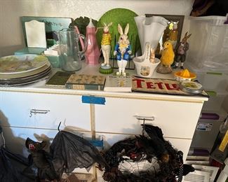 Easter bunnies, chicks, pitchers, coffee pot, ruffled glass vase, bat, Halloween wreath, vent covers, storage bins, sorry cabinet is built in