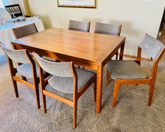 Danish Modern teak expanding dining table with 6 chairs.  Table expands from 55”W to 94 1/2”W when the two hidden leaves come out.  35”D and 28 1/2”T