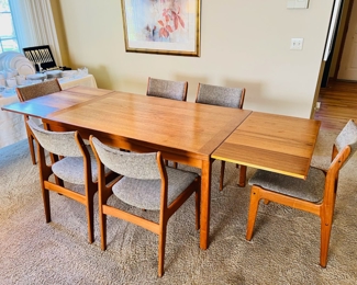Danish Modern teak expanding dining table with 6 chairs.  Table expands from 55”W to 94 1/2”W when the two hidden leaves come out.  35”D and 28 1/2”T