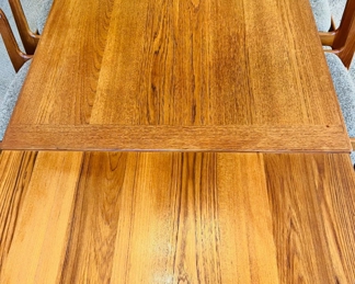 Danish Modern teak expanding dining table with 6 chairs.  Table expands from 55”W to 94 1/2”W when the two hidden leaves come out.  35”D and 28 1/2”T