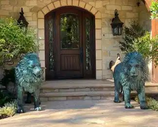 European bronze  lions.  Circa 1960s.  Each lion weighs over 300 lbs. and stands 44" tall  /  60" long.  This pair of lions were removed from an English Manor House and imported from England in the 1980's.  