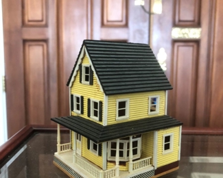 A tiny scale of a wood dollhouse by Millie August