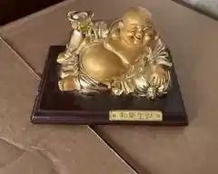 Gold tone reclining laughing Budda