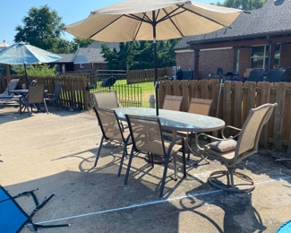 Glass table with six metal chairs(two arm chairs), metal umbrella, and ceramic lighthouse 
