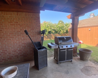 Webber gas grill, metal outdoor torch, outdoor rubber garage can, and large outdoor rubber chest 