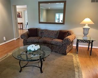 3-cushion couch, metal and glass tables, large gold mirror, and table lamp