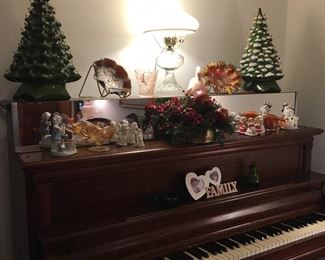 Upright Piano with variety of ceramic Christmas trees and decorations