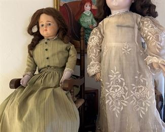 Close up of the French Bebe doll and a period cloth body doll in rocking chair.