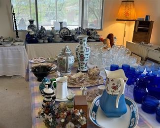 The tables are loaded with decorative porcelain, blue and white, and glassware.