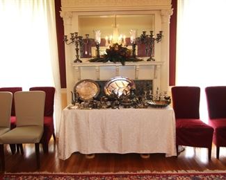 Six of the twelve Pottery Barn slipcovered chairs shown with display of silver plate items.