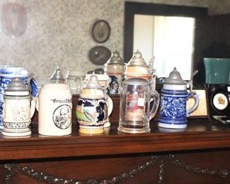 Mantle top full with nice beer steins and pottery.