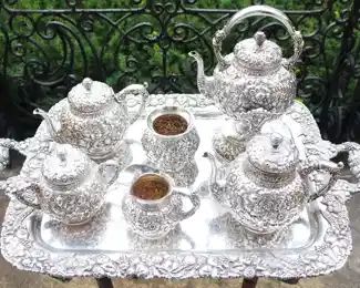 Repousse style seven piece sterling silver tea service.  W.H. is the marking on the underside.  Believe it to be by Wood & Hughes.  The tray we have chosen to show it on is silverplate.                                                                                                     NOTE:  THESE ITEMS ARE NEVER LEFT UNATTENDED OR IN THE HOUSE OVERNIGHT!