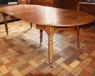 Oak Round Table, Five Legs, Eight Leaves.                               77" L x 44" W x 28 1/2" H. Six Leaves are 14" W.