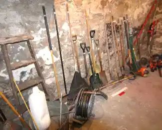 Assortment of garden tools, shovels, rakes, hoses, trimmers and more.