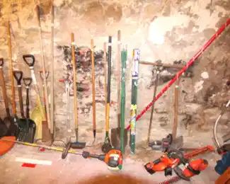 Assortment of garden tools, shovels, rakes, hoses, trimmers and more.