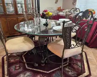 round glass top table with metal base and four chairs