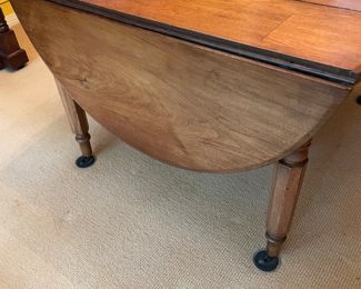 This table is soooo charming that my clients used it for their formal dinning  table with 8 antique Chippendale formal chairs.  An antique 19th century solid walnut oval drop leaf extension table with 5 legs and 4 leaves. Solid walnut five turned legs. Four solid walnut original leaves. Table is in a clean original finish. Original casters. Original custom primitive drop leaf brackets. All original parts and in good working order.  This table has a super charming primitive patch on the main table surface.