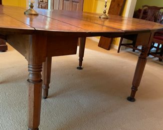 This table is soooo charming that my clients used it for their formal dinning  table with 8 antique Chippendale formal chairs.  An antique 19th century solid walnut oval drop leaf extension table with 5 legs and 4 leaves. Solid walnut five turned legs. Four solid walnut original leaves. Table is in a clean original finish. Original casters. Original custom primitive drop leaf brackets. All original parts and in good working order.  This table has a super charming primitive patch on the main table surface.